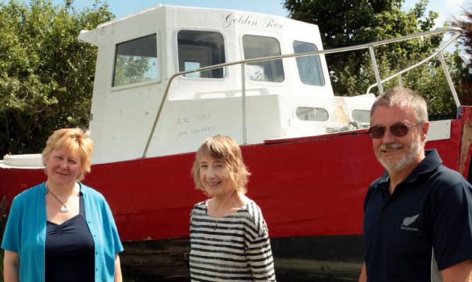 Wendy Murray, Moira Beattie and Ian Bancroft of the Easthaven 800 committee with the boat after it was transported to the village.