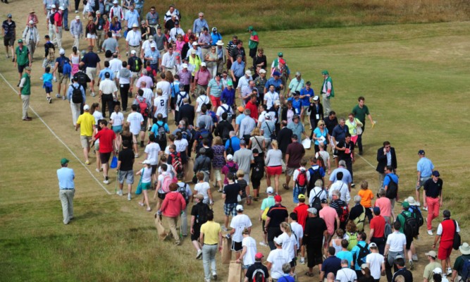 Crowds cross the 18th fairway during The Open.