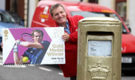 Postman John Elliot next to Dunblane's gold postbox.