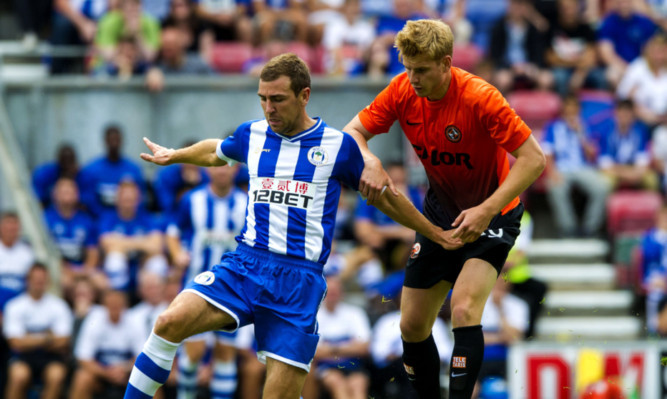 Wigan's James McArthur (left) and Dundee United's Stuart Armstrong battle for possession.