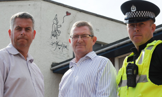 From left: Councillor Brian Boyd, Ross Smyth and PC Steve Borland outside the Beach Hall in Carnoustie where the latest graffiti has appeared.