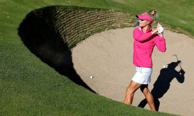 Carly Booth playing from the Road Hole bunker at the 17th green during practice.