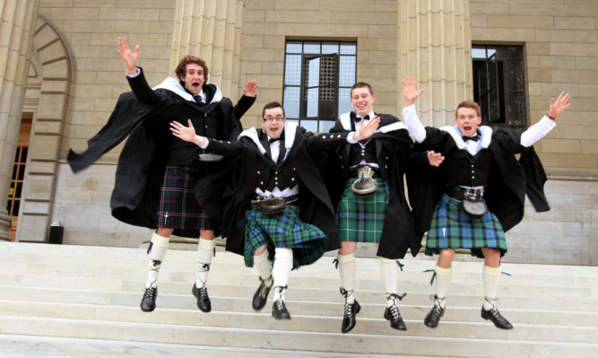 All smiles: a group of four students celebrate graduating earlier this year.