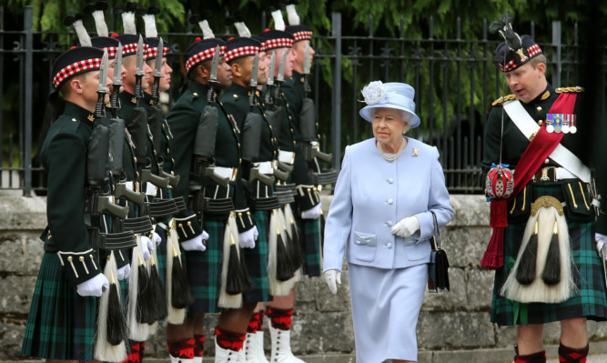 The Queen inspecting troops at the gates of Balmoral.