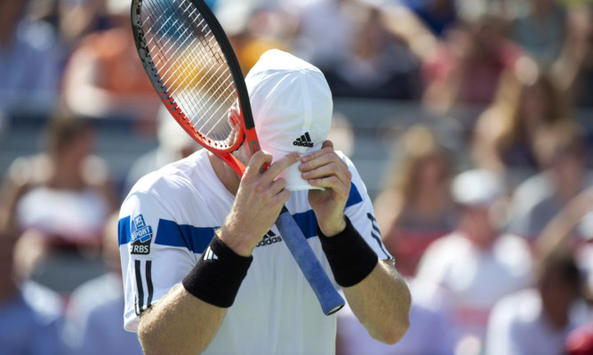 Andy Murray buries his head in his cap during his defeat to Ernests Gulbis.