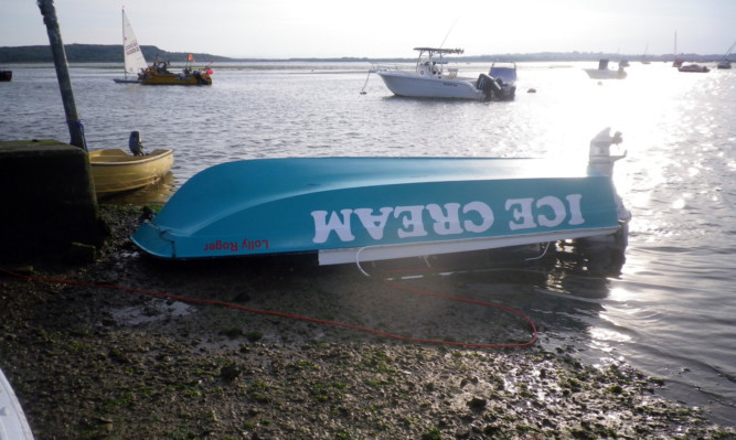 A Mayday call was made to coastguards when a motor cruiser spotted the capsized vessel and three-man crew in water.