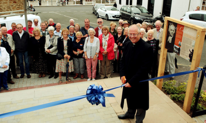 Rev Arthur Christie, Moderator of St Andrews, cuts the ribbon to open the new garden.