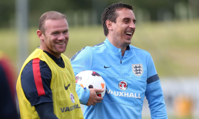 Wayne Rooney and assistant coach Gary Neville are all smiles during Englands training session.
