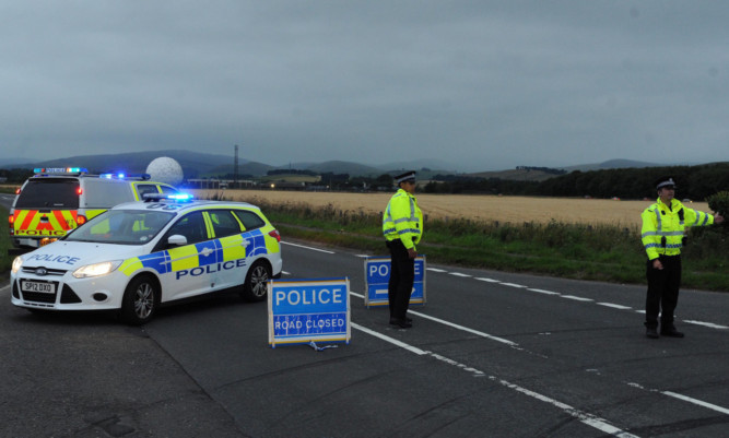 Police man a road block near the scene of the accident at Balado