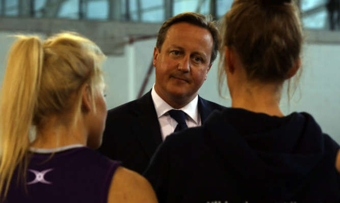 Mr Cameron speaks with athletes at the Emirates Arena.