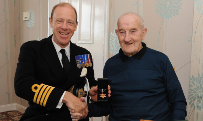 Captain Smith presents Mr Lawson with his medal.