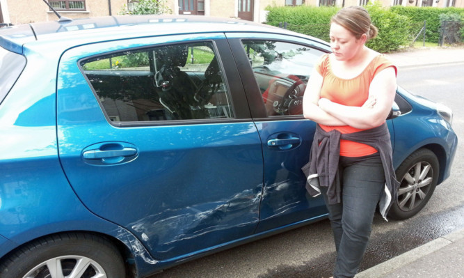 Staff nurse Heather Kinney with her damaged car.