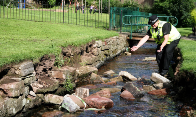 PC Gail Beattie showing the rocks that fell into the burn at The Den in Kirriemuir.