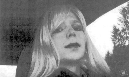 Manning poses for a photo wearing a wig and lipstick.