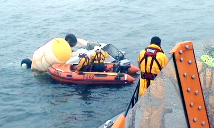 RNLI volunteers and the coastguard inspecting the wreckage of the Super Puma L2 helicopter.