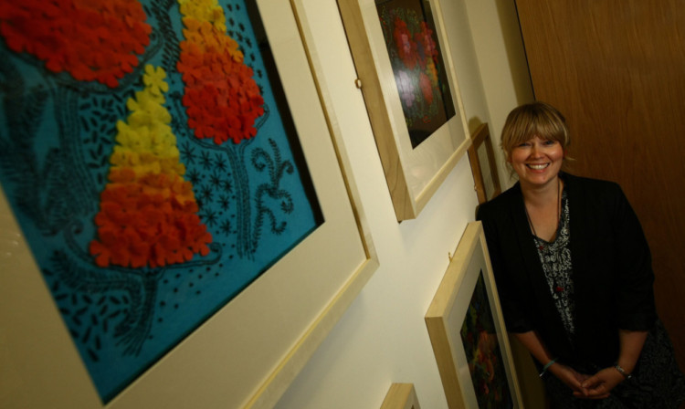 Artist Sarah Jacobs beside some of her work, which is now brightening the corridor leading to the Spiritual Care Centre at Perth Royal Infirmary.