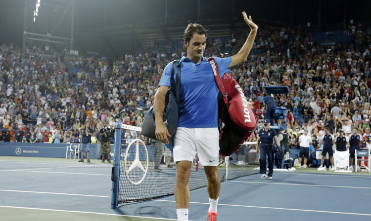 Roger Federer walks off the court after losing in straight sets to Tommy Robredo.