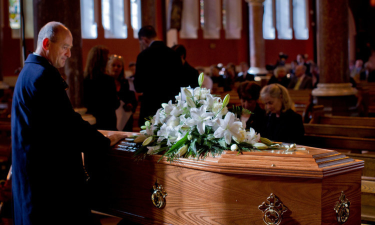 A mourners lays his hands on the coffin of Nobel Laureate poet Seamus Heaney before his funeral in Dublin.