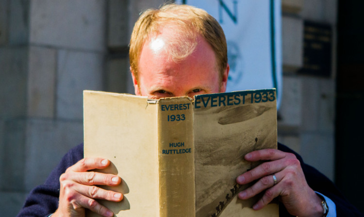 Auctioneer Nick Burns with a first edition book on the 1933 Everest ascent by Hugh Ruttledge, simply called Everest 1933.