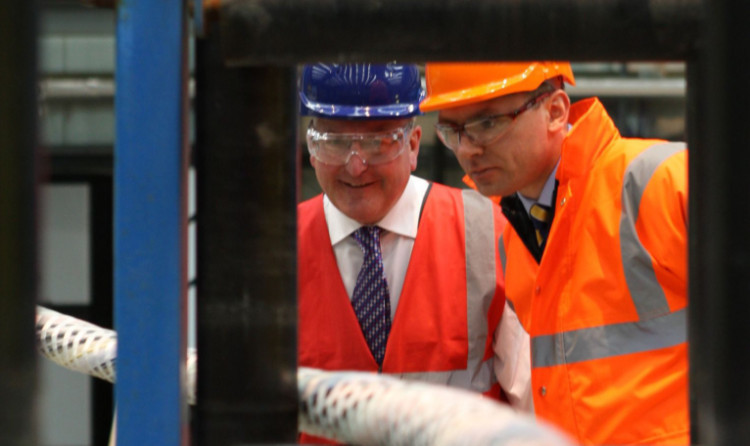Fergus Ewing MSP and Oceaneering general manager Gary Cochrane looking at one of the umbilical cables being produced at the firms Rosyth plant.