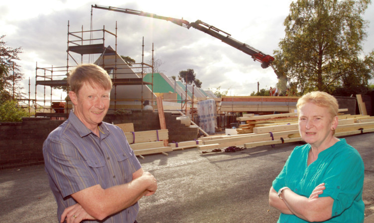 Robert and Margaret McVean watch their new home being built.