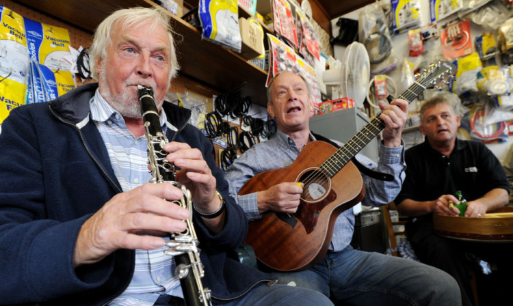 Ken Muir, Dennis Collie and James Gore perform in George Rennies electrical shop.