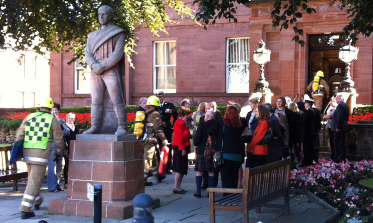 The dignitaries outside the library as firefighters arrive to check the building after the fire alarm sounded.