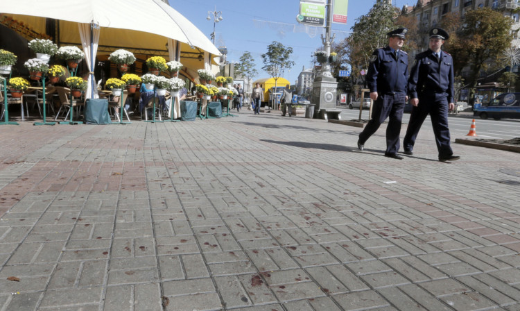 Police walk past a blood-spattered pavement in central Kiev.