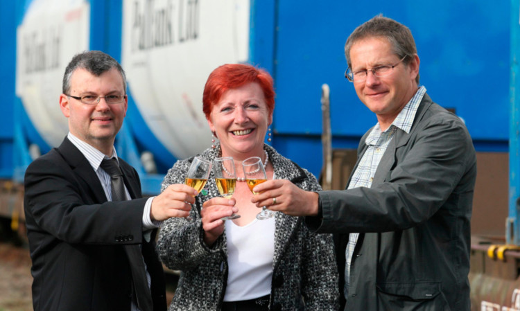 Tony Jarvis of HIE, Moray councillor Fiona Murdoch and Hitrans partnership manager Frank Roach raise a glass at Elgin Goods Yard as the trial commences.