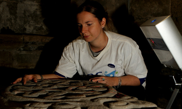 At the Old Steeple on Saturday is Gemma Hudson, archaeological surveyor with A.O.C. Archaeology Group, scanning the coffin cover of the Ship Stone from the 1300s.