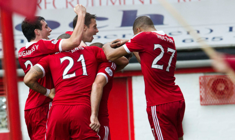 Scott Vernon is mobbed by his team-mates after giving Aberdeen the lead.