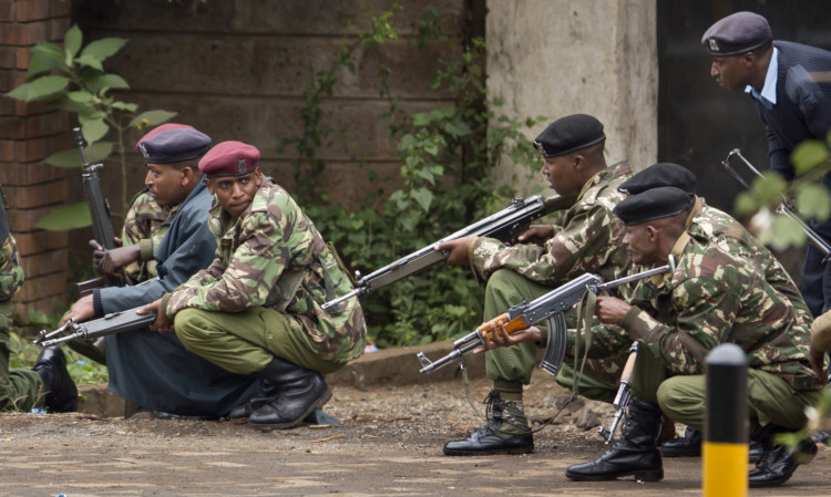 Armed police from the General Service Unit take cover behind a wall during a bout of gunfire, outside the Westgate Mall in Nairobi, Kenya.