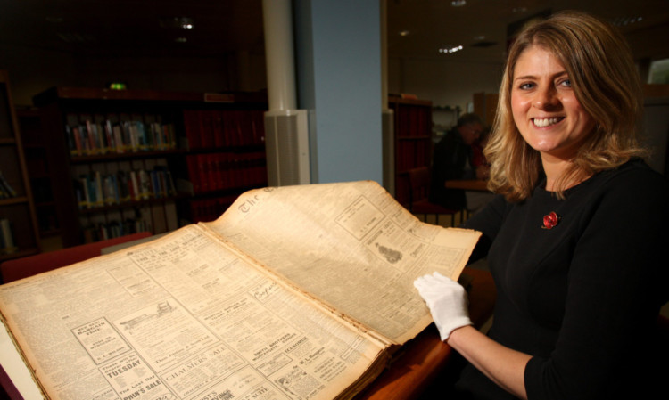 Amina Shah of Dundee Libraries looks through old editions of The Courier.