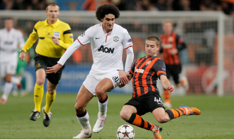 Manchester Uniteds Marouane Fellaini is challenged by Shaktar Donetsks Yaroslav Rakitskiy.