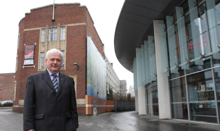 Council leader Ian Miller in front of the building that is to be converted into a hotel, with the curve of Perth Concert Hall alongside.