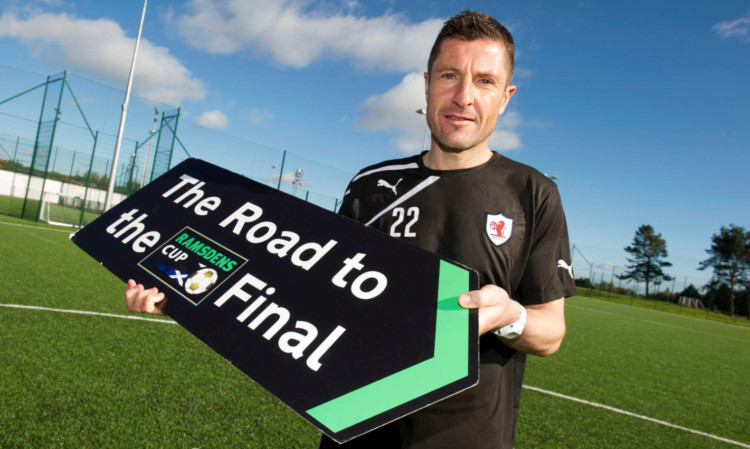 Grant Murray holds a sign saying 'The Road to the Final' ahead of Raith Rovers' Ramsdens Cup success in 2014.