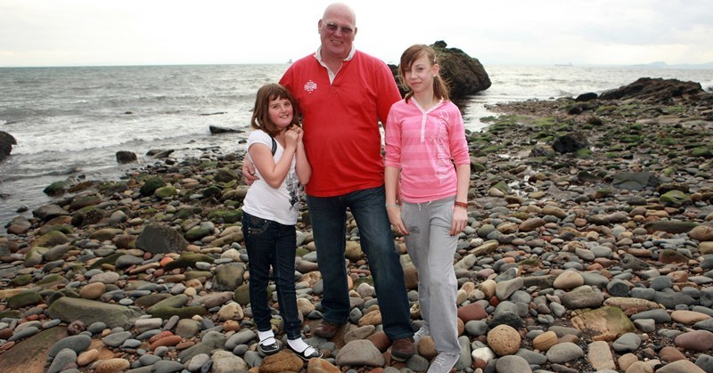 Bob Douglas, Courier. The girls revisit the scene of their dramatic rescue. Left, Danielle Gourlay and Katie Dorward, right, with Brian McCallum (Danielle's grandad not sure about Katie) and the rock behind on the beach at Pan Ha', Dysart.