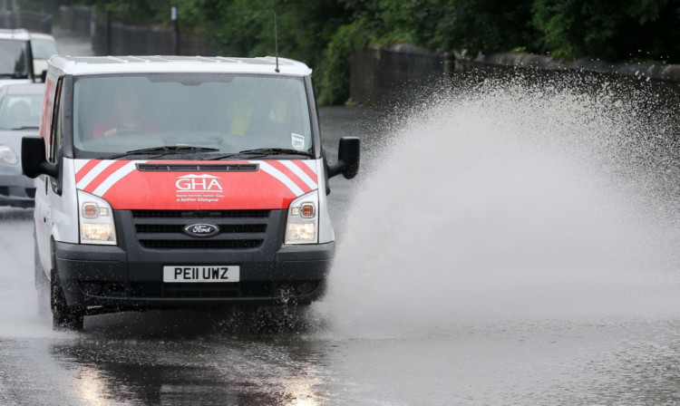 A van makes its way through partially flooded roads during heavy rain in Glasgow, Scotland. PRESS ASSOCIATION Photo. Picture date: Tuesday July 23, 2013. See PA story WEATHER Storms. Photo credit should read: Andrew Milligan/PA Wire