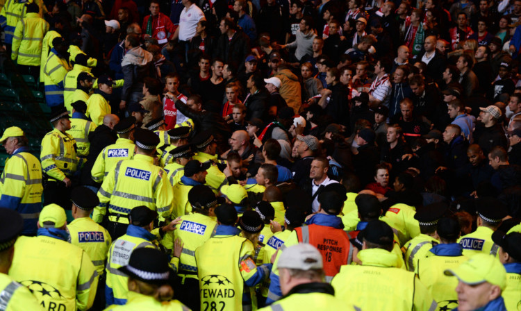 Police and stewards dealing with Ajax fans in the aftermath of Celtic's opening goal.