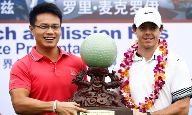 Rory McIlroy is presented with the trophy after defeating Tiger Woods in China.