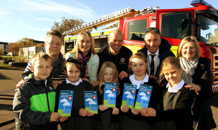 Pupils from Ladyloan Primary with Tracey Furness (Smoke Free Homes project worker) , Kelly Cruickshanks (smoking cessation co-ordinator) , firefighter Gavin Coull , Bonnie Truop (public health nurse) and Alex Colquhoun (staff tutor).