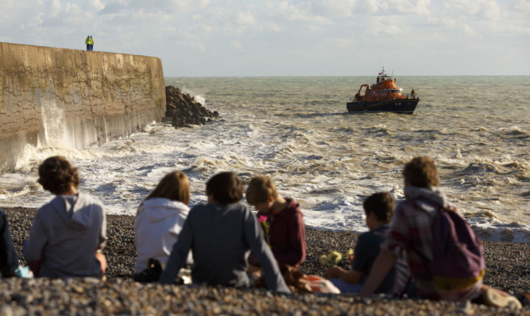 Friends of Dylan Alkins, who was swept out to sea, hold a vigil at West Beach in Newhaven.