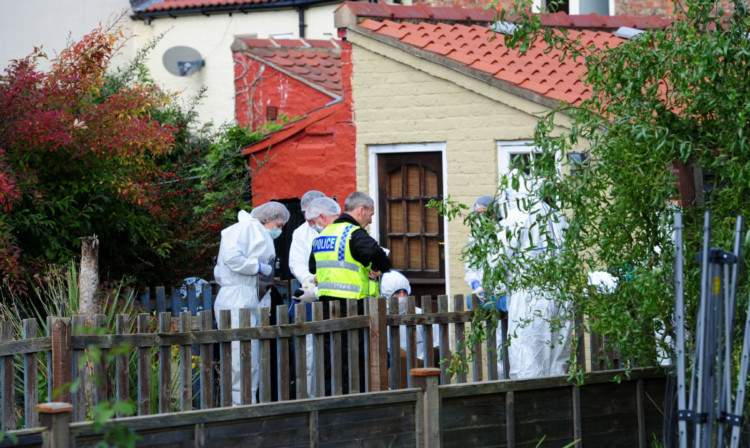 Forensic officers in the back garden of the home.
