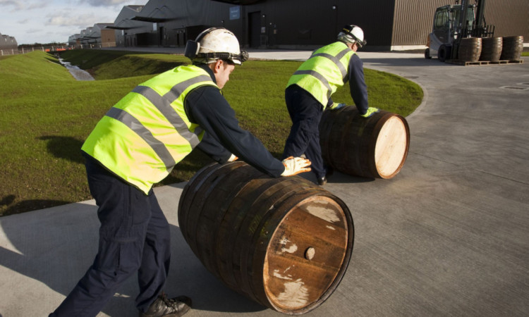 Diageo workers roll in the barrels.