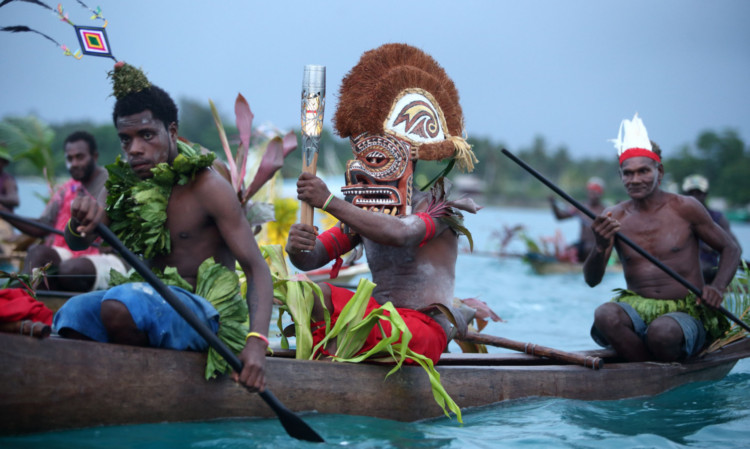 The baton is transported by wooden canoe from Kavieng to Nusa island in Papua New Guinea yesterday.