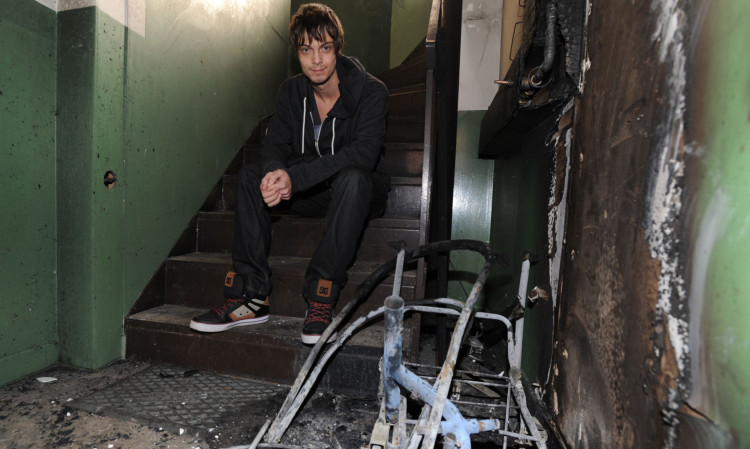 Tenant Sam Rowland beside the pram that was set on fire.