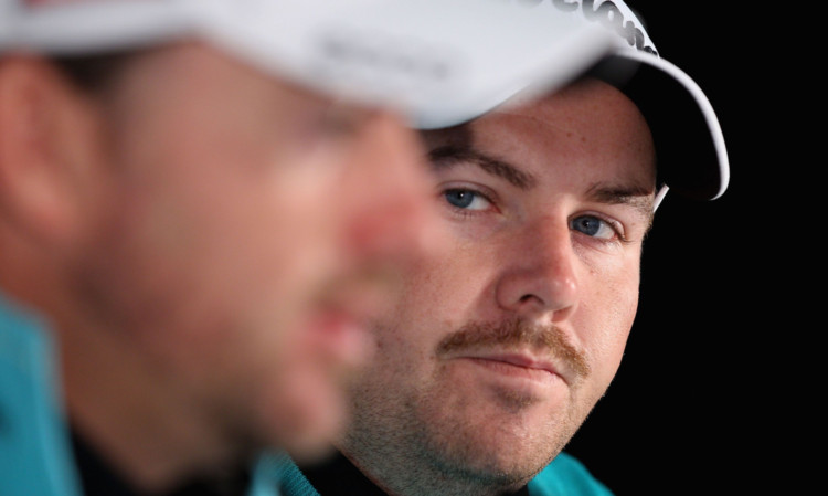 Shane Lowry (right) looks on as Graeme McDowell speaks to the media.