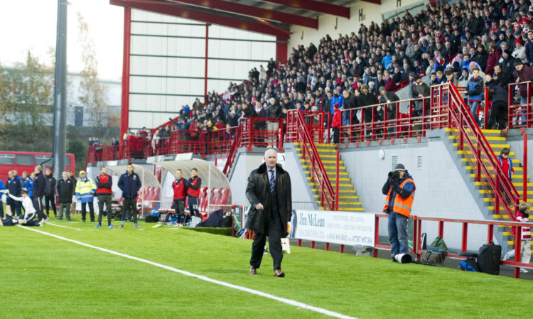 Dundee manager John Brown walks down the touchline to address the threat of crowd trouble by speaking with fans.