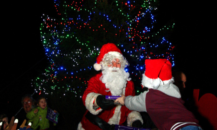 Santa hands out presents to children during the Christmas lights switch-on.