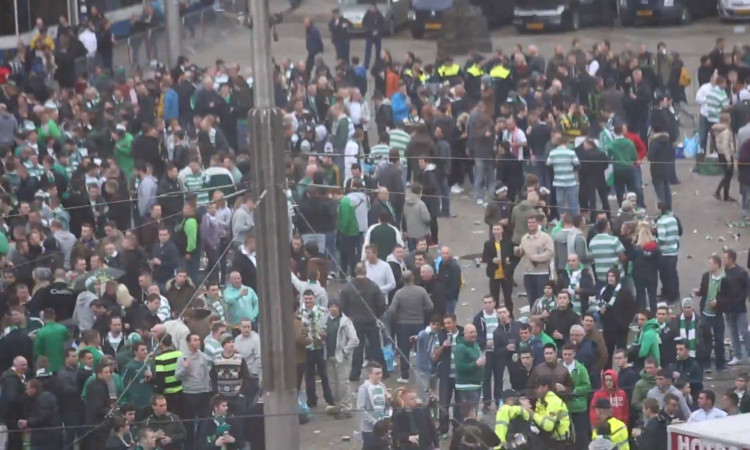 Celtic fans from Dundee have claimed they were among supporters attacked by plain-0clothed officers in Amsterdam.